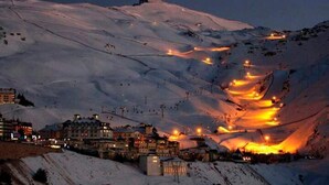 A snow-covered mountain with ski slopes and a town at the base. - Snow covered Apartment in Sierra Nevada (Sierra Nevada)