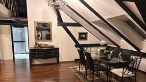 Ein Essbereich mit Tisch, Stühlen, einer Chandelüster und einem Spiegel an der Wand.
