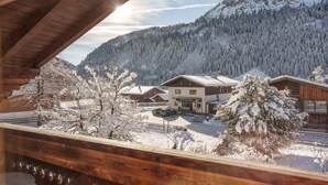 A snowy mountain village with wooden buildings and a clear view of the surrounding forest. - Klimbim Wohnen und Erleben Annette (Nesselwängle)