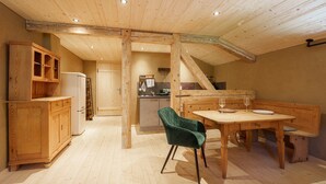 A wooden interior with a dining area, kitchen, and a staircase. - Klimbim Wohnen und Erleben Annette (Nesselwängle)