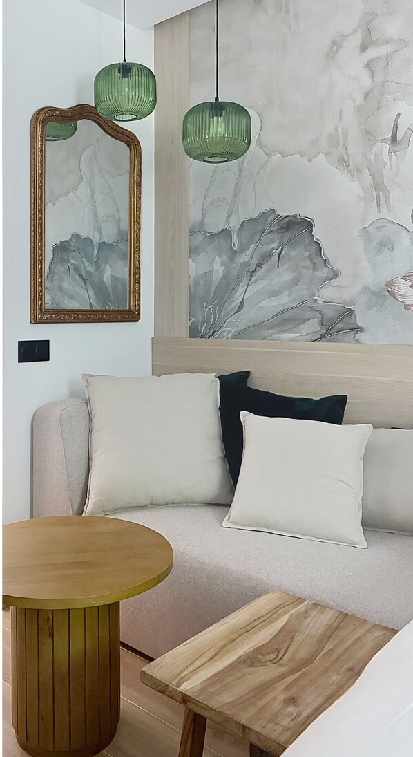 Ein modernes Wohnzimmer mit einer Couch, einem runden Holztisch und einem Gemälde an der Wand.