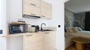 A compact kitchen with a built-in stove, microwave, and sink. - T2 Luxury Canet • Beach 50m - Romantic stay ❤️ Love room (Canet-en-Roussillon)