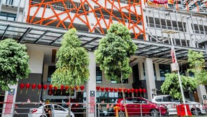 Hotel com design moderno, destacando uma fachada geométrica marcante em vermelho e branco.