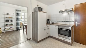 A modern kitchen with white cabinets, a built-in oven, and a microwave. - Apartment 'Hoppernkopf' with Shared Terrace, Private Garden and Wi-Fi (Willingen (Upland))