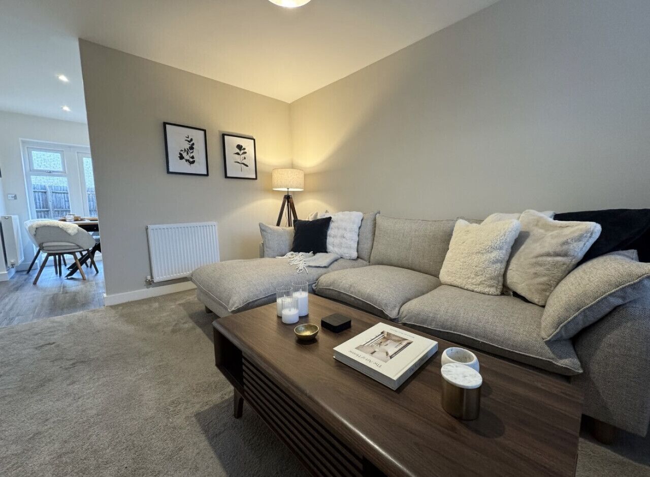 A modern living room with a grey sofa, a wooden coffee table, and a floor lamp.