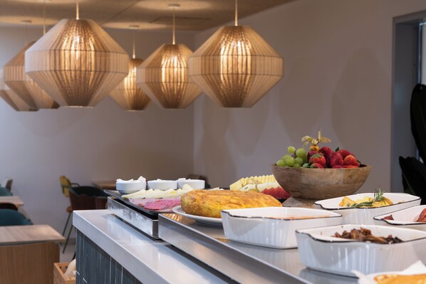 A buffet with various food items and a fruit bowl.