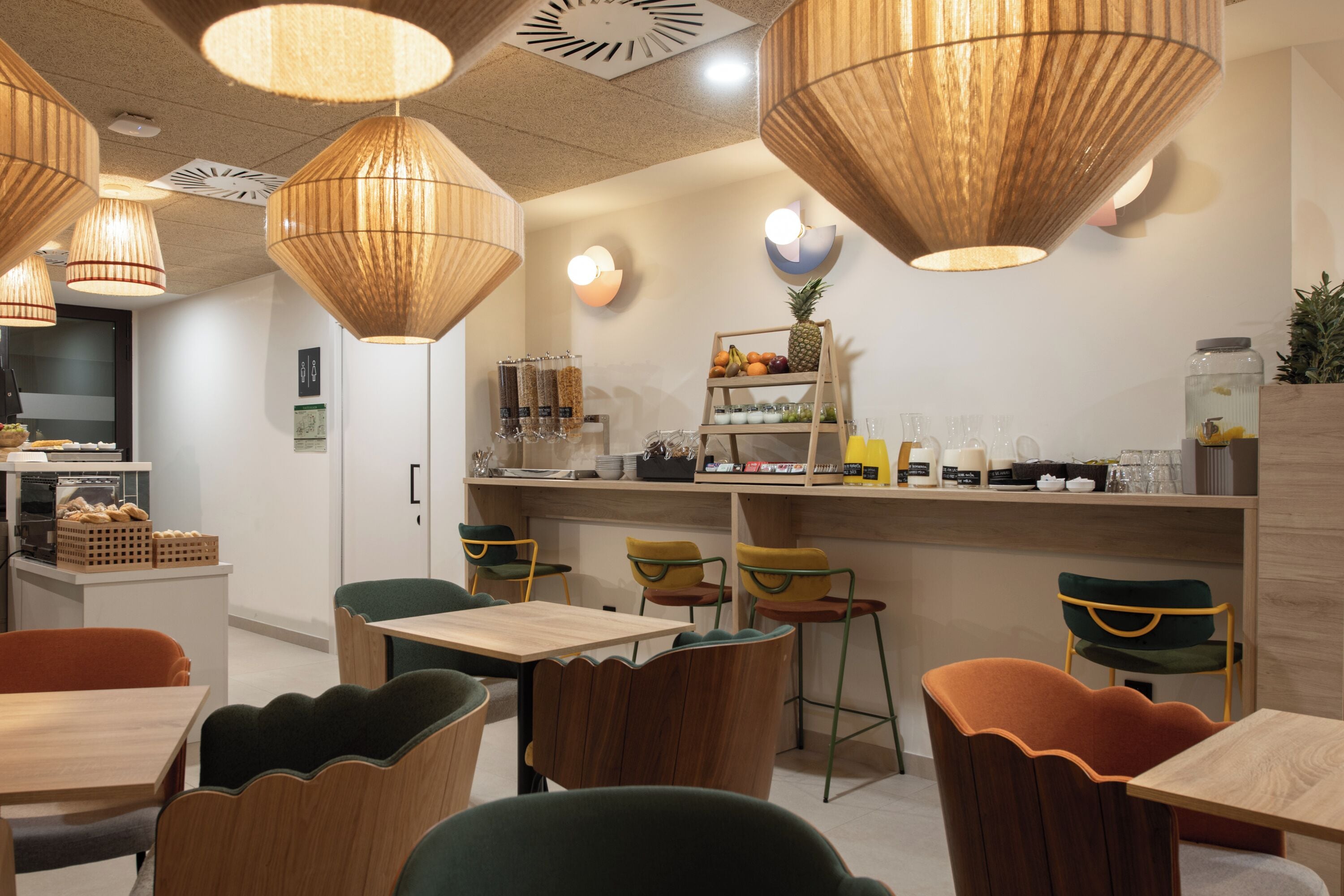 A restaurant interior with wooden furniture, hanging lamps, and a bar area.