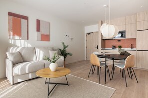 A modern living room with a sofa, coffee table, and dining area.