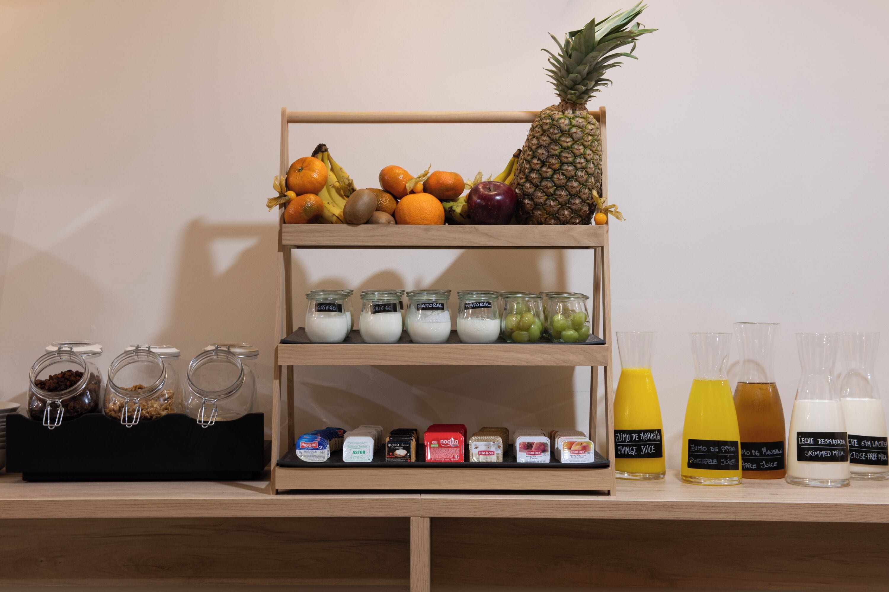 A breakfast bar with fruits, yogurt, and juice.