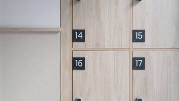 Een rij lockers met de nummers 14 tot en met 17, een bord erboven met de tekst 'lockers', en een afstandsbediening hangend aan de muur.