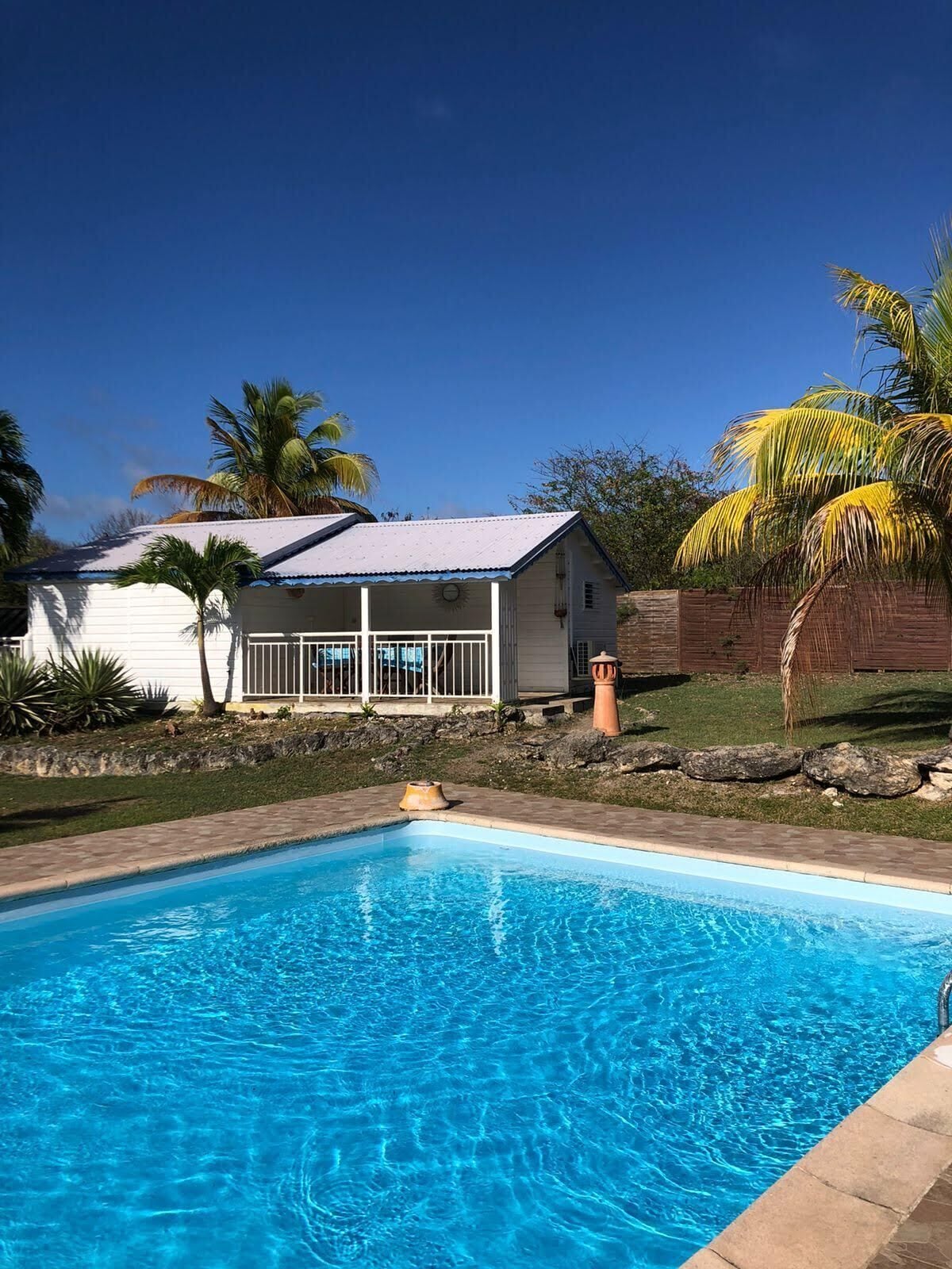 Una piscina con una casa al fondo.