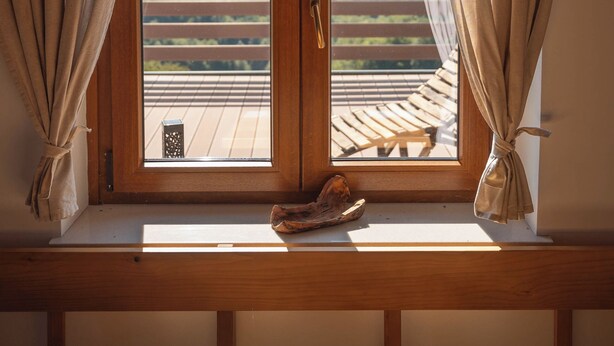 A wooden bench with a view of a balcony and a wooden railing. - Vineyard cottage Mehak (Sevnica)