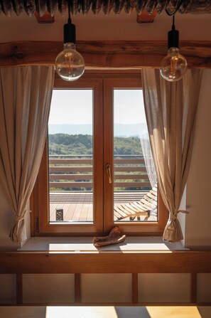 A wooden bench with a view of a balcony and a wooden railing. - Vineyard cottage Mehak (Sevnica)