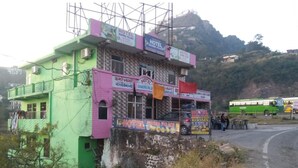 A multi-story building with signs for 'Hotel Sharna Palace' and 'Hotel Sharna Palace'. - Hotel Sharma Guest House  (Naina Devi)