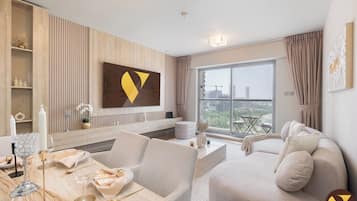 Apartamento de lujo, balcón, vistas a la ciudad | Zona de estar | Smart TV de 65 pulgadas con canales por satélite