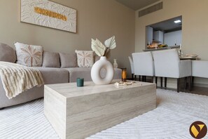 Departamento de lujo, balcón, vista a la ciudad | Área de sala de estar | Smart TV de 65 pulgadas con canales vía satélite 