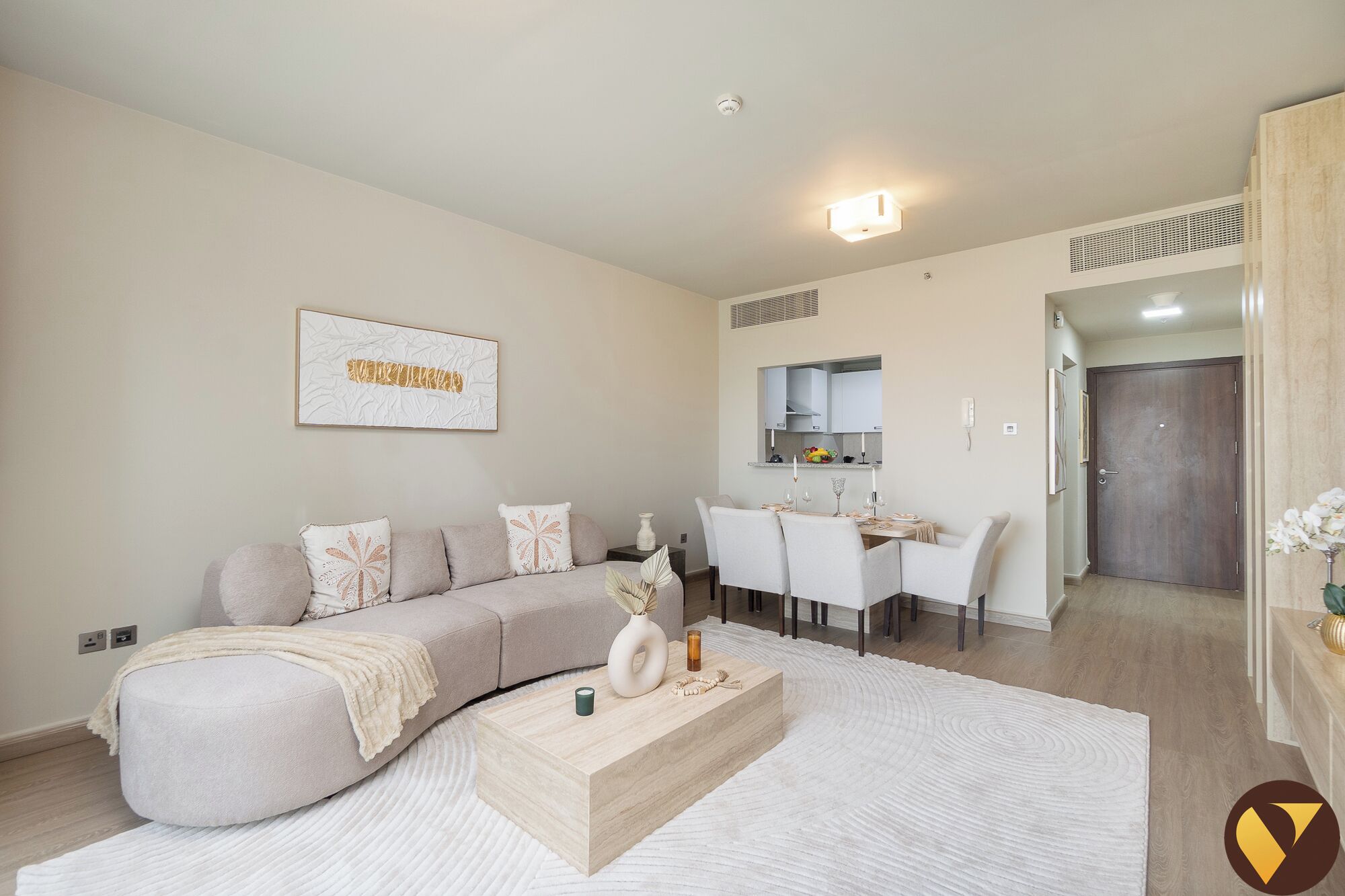 A modern living room with a sofa, coffee table, and a dining area with chairs and a table.