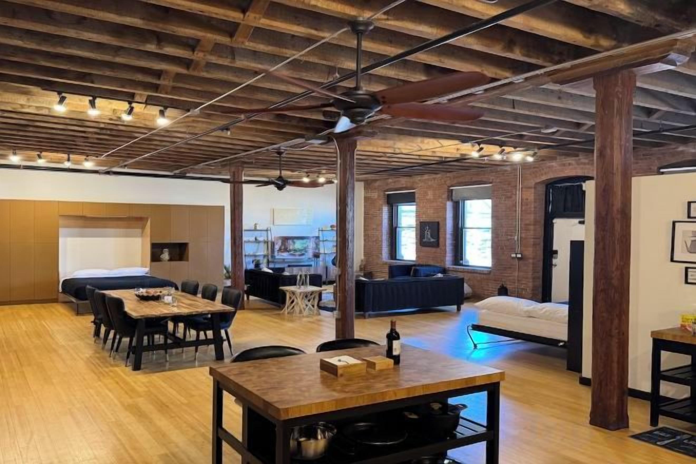 An open-plan living space with a dining area, seating, and a kitchen.