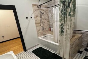 A bathroom with a shower, a bathtub, and a toilet. - Brick City Loft (Newark)