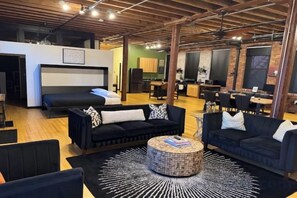 A modern interior with a sofa set, a round coffee table, and a bunk bed. - Brick City Loft (Newark)