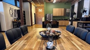 A conference room with a long wooden table, black chairs, and a decorative centerpiece. - Brick City Loft (Newark)