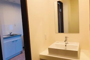 A bathroom with a white sink, a mirror, and a blue cabinet.