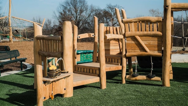 A wooden play structure with a slide and climbing elements, surrounded by artificial grass. - King Bed 2BR Retreat, Private Garage (Kansas City)