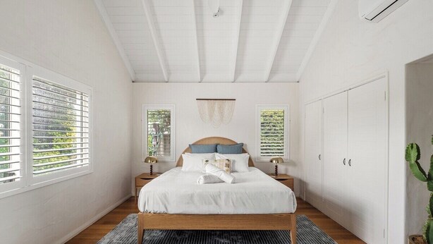 A bedroom with a bed, nightstands, a window, a ceiling fan, and a potted plant. - Saltwood: Yallingup Garden Sanctuary by the Sea (Yallingup)