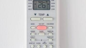 A white Midea air conditioner unit with a digital display, control buttons, and a brand logo.
