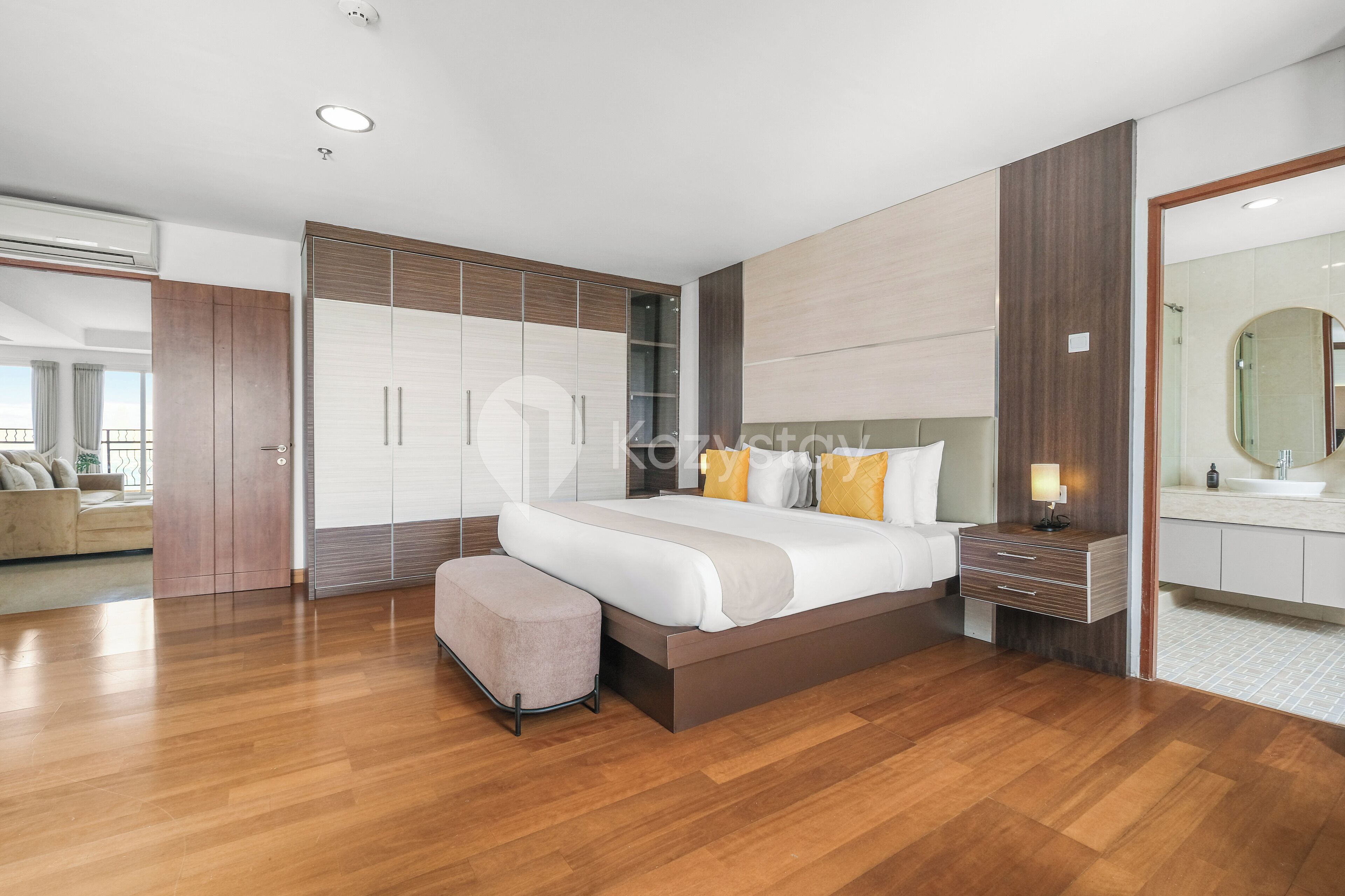 Un dormitorio moderno con una cama grande, una mesita de noche, un banco y un vestidor.