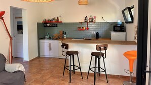 A kitchen with a wooden countertop, two bar stools, a hanging light fixture, and a tiled backsplash. - Summer rental Ajaccio (Ajaccio)