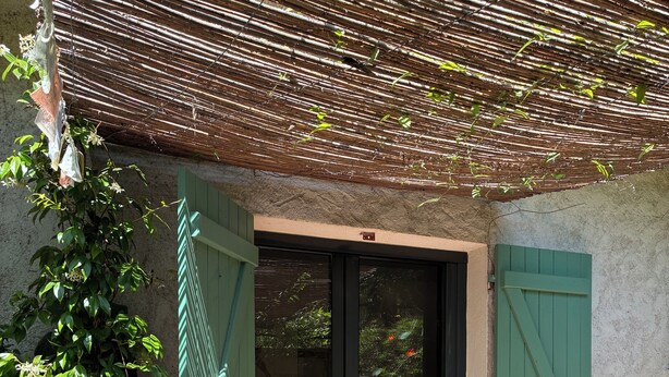 A covered outdoor area with a sliding glass door, a green door, and a tiled floor. - Summer rental Ajaccio (Ajaccio)