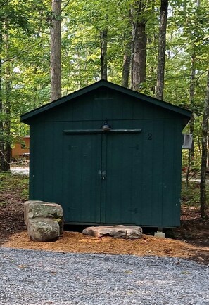 A green shed with a door, number 2, in a wooded area. - Peaceful Bunkhouse Surrounded by Nature near Graysville, Tennessee (Graysville)