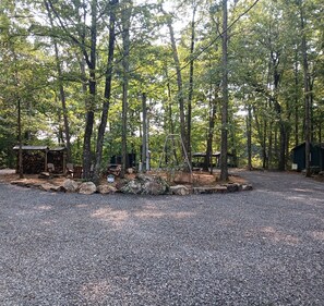Ein Campingplatz mit Kiesfläche, Holzhütten und einer Schaukel.