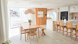 Una cocina moderna con una isla de mármol, armarios de madera y un ventanal amplio.
