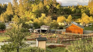 A rural property with a fenced area, a small shed, and a large barn.