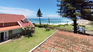 A house with a red tiled roof overlooking a beach. - Billy Bay Cottage (Margate)