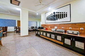 A spacious room with a long counter, chairs, and a projector screen. - Hotel Sky View at Delhi IGI Airport (New Delhi)