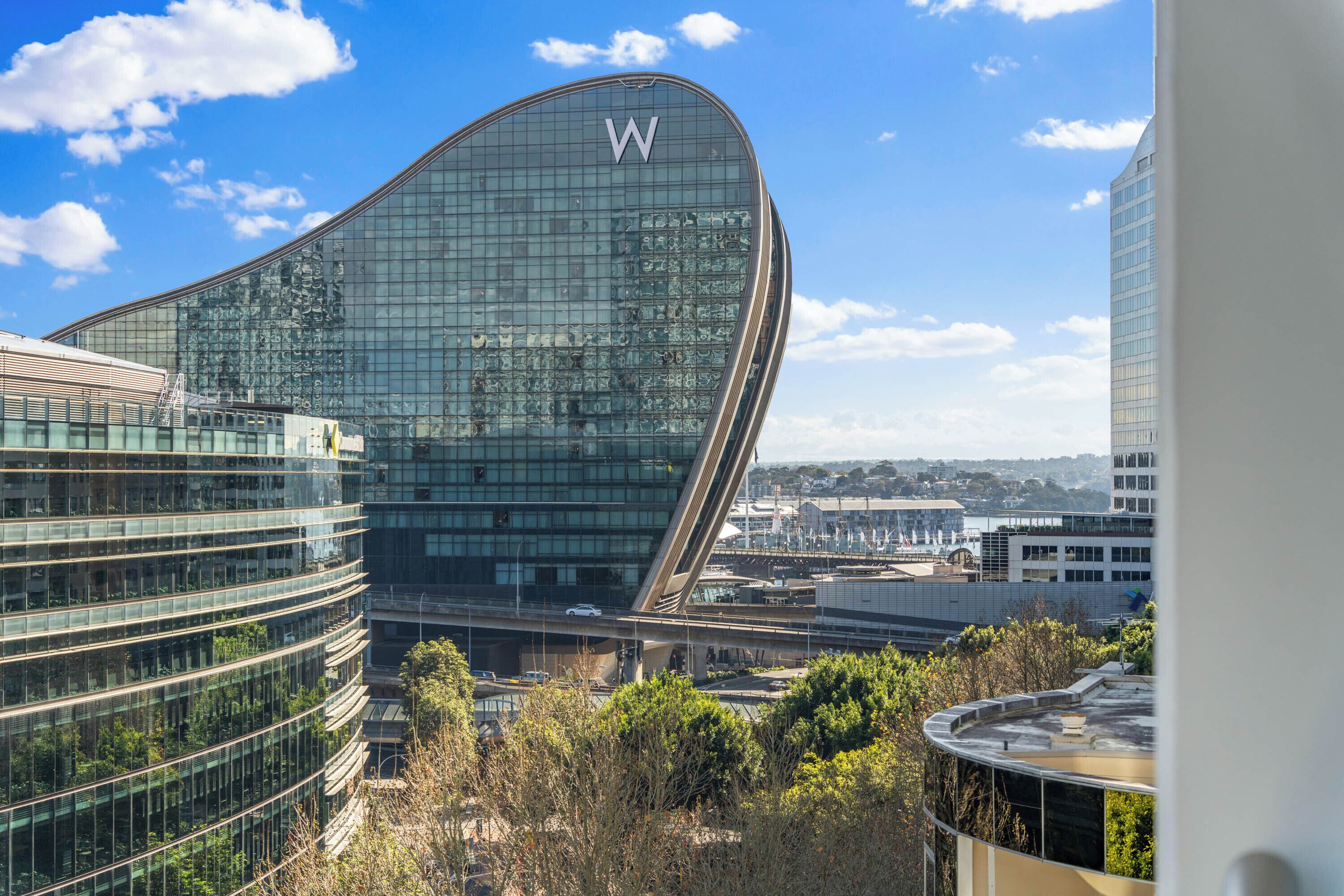 A modern building with a curved glass facade and a prominent 'W' logo.