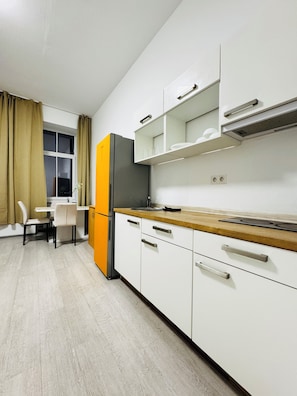 Eenvoudig appartement | Privékeuken | Een koelkast, een kookplaat, kookgerei, borden en bestek