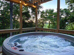 A hot tub with a wooden deck and a pergola overhead. - Hot Tub Log Cabin | Shipshewana | Outdoor Living | (Shipshewana)