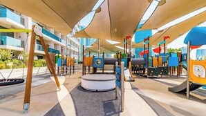 Un espace de jeux extérieur doté de diverses structures d’escalade et d’un espace de repos circulaire.