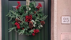 A green door with a Christmas wreath, a house number plaque, and a doorbell. - Romantic retreat with a private panoramic terrace near the Saturnia Hot Springs (Manciano)