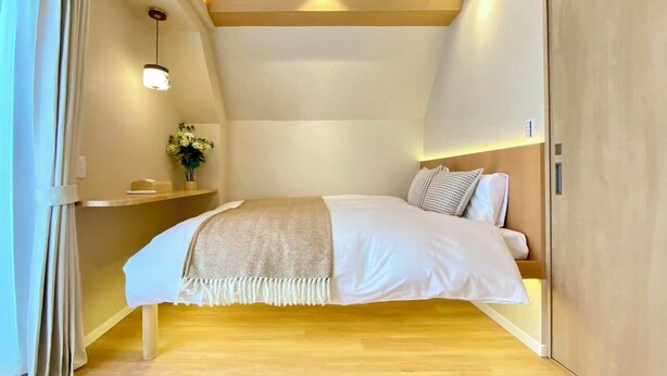Ein Schlafzimmer mit einem Bett, einem Nachttisch und einem Beistelltisch mit Lampe.