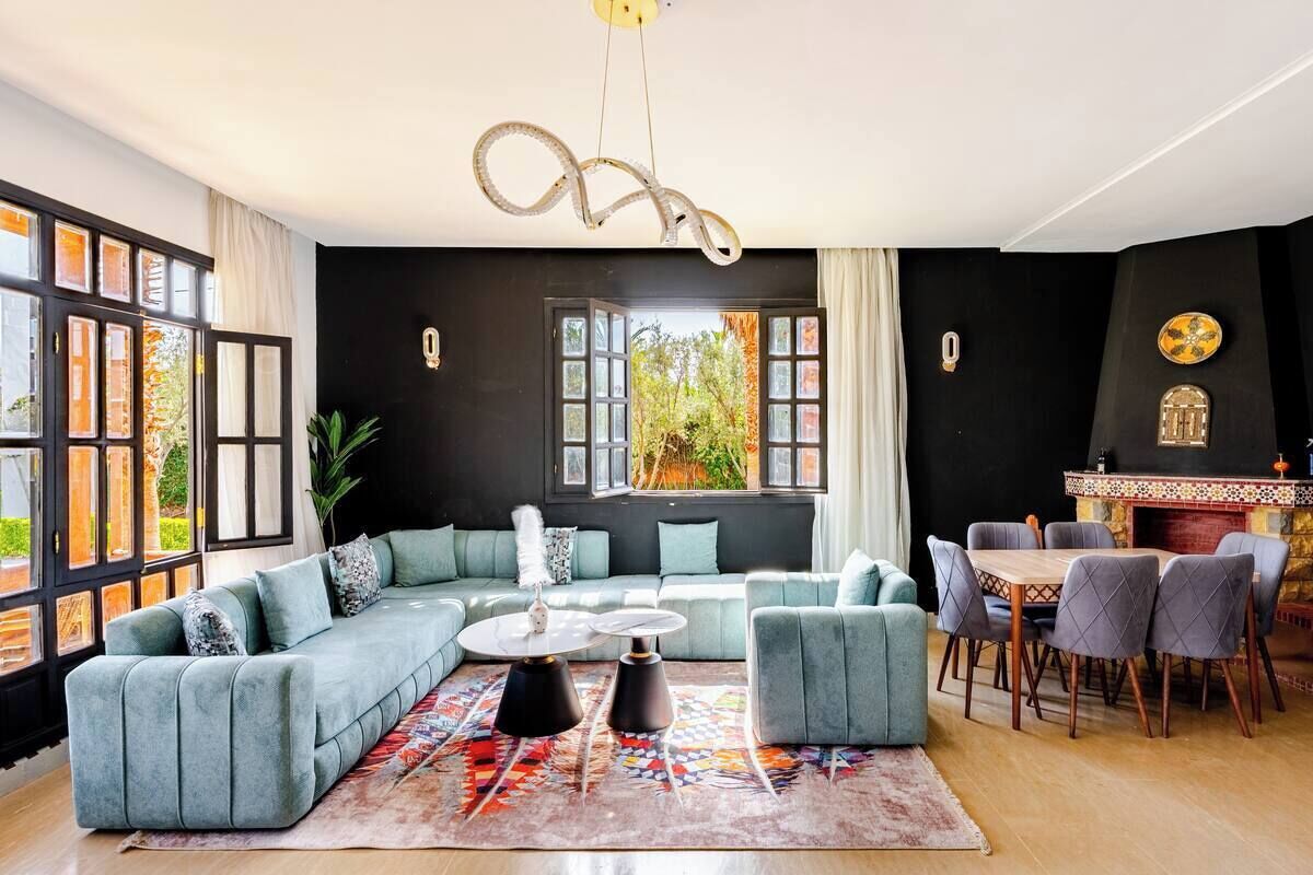 A modern living room with a sectional sofa, a round coffee table, and a dining area with chairs.