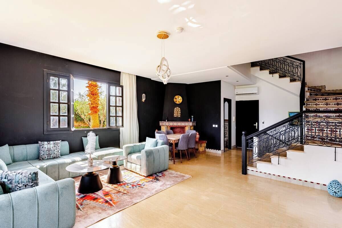A modern living room with a sofa set, a coffee table, and a dining area with chairs.