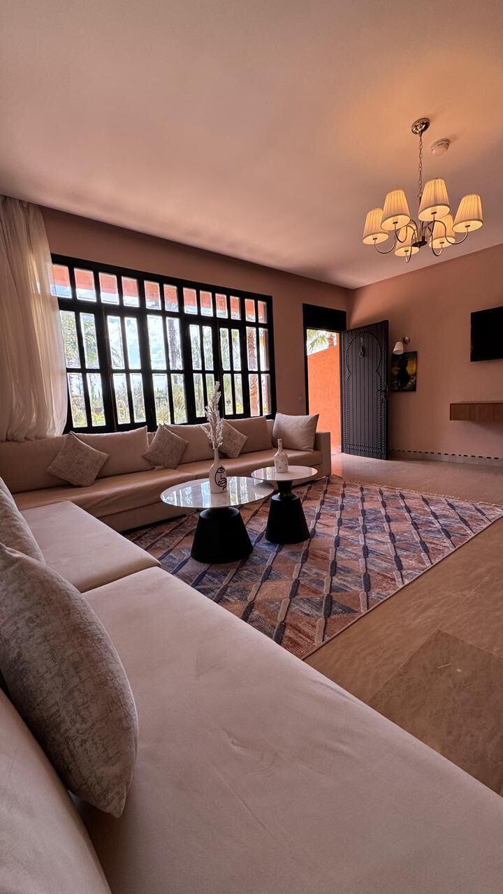 Ein modernes Wohnzimmer mit einer Couch, einem Couchtisch und einer Deckenleuchte.