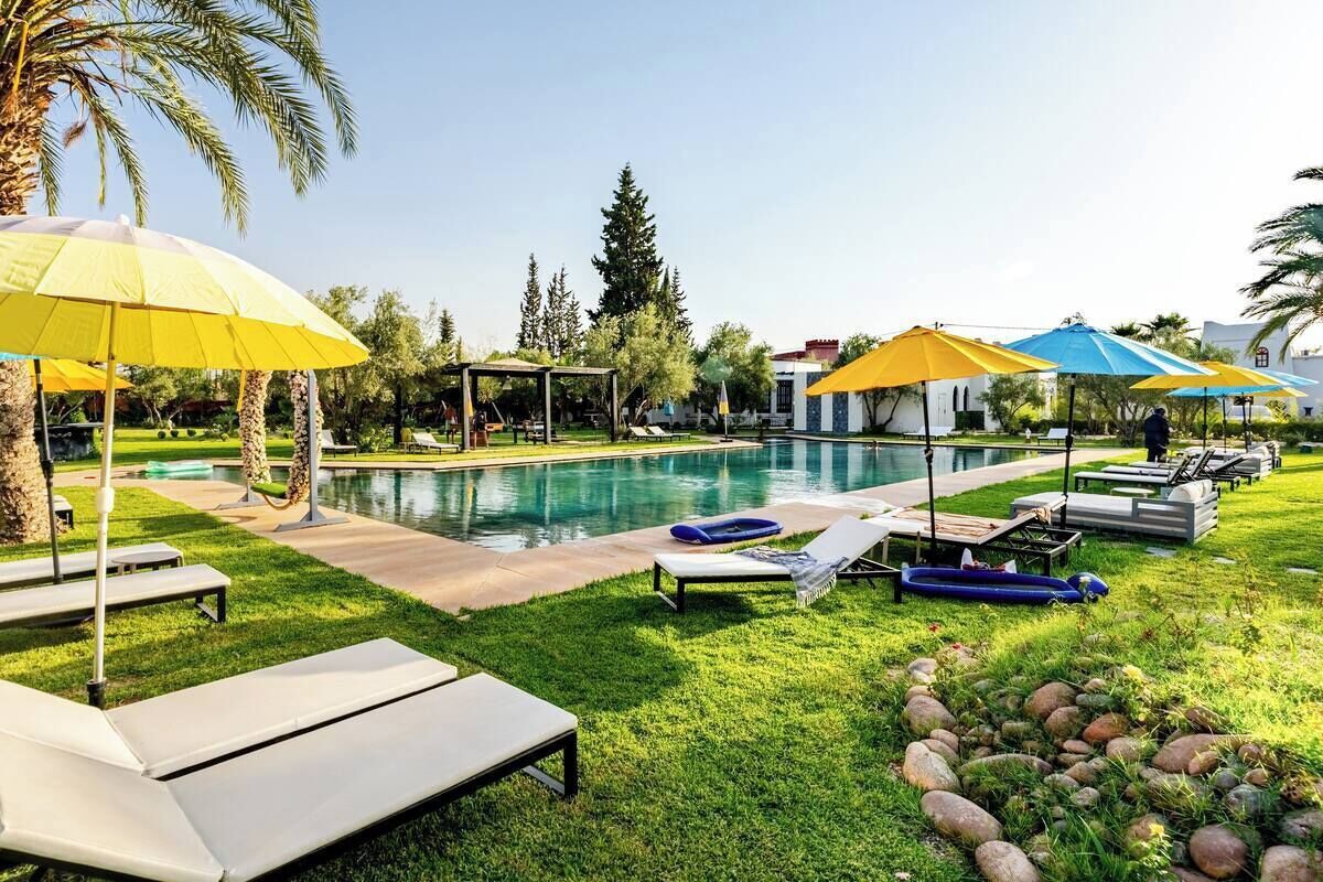 A poolside area with lounge chairs, umbrellas, and a clear view of the pool.