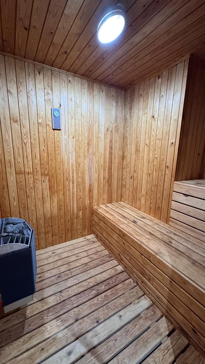 Una sala de sauna con paredes y bancos de madera.