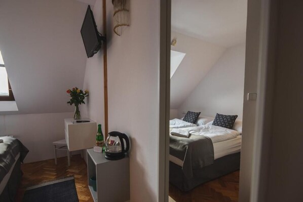 A bedroom with a bed, a small desk, a television, and a window. - Hotel Petřín (Jablonec nad Nisou)